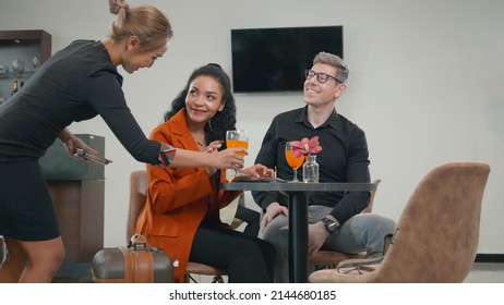 Airport Lounge. Business Man And Woman Meeting And Talking Together And Staff Serving Orange Fruit Juice, Businessman And Businesswoman During Waiting For Their Flight At Airport Terminal