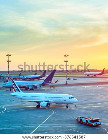 Airport with many airplanes and beautiful sunset sky