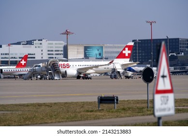 Zürich Airport with parked Swiss airplanes on a blue cloudy spring day. Phot taken March 26th, 2022, Zurich, Switzerland.
