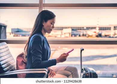 Airport phone travel Asian businesswoman using mobile smartphone in business class lounge waiting for plane flight texting sms message. Technology and travel people VIP lifestyle. - Powered by Shutterstock