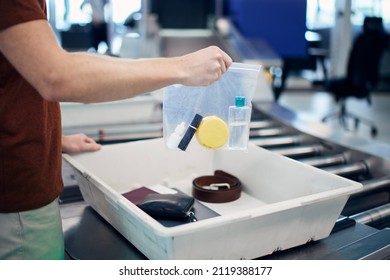 Airport security check before flight. Passenger holding plastic bag with liquids above container personal items.  - Shutterstock ID 2119388177