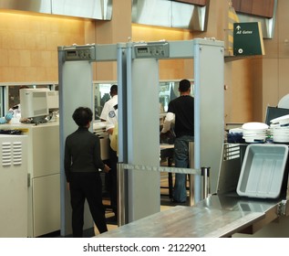 Airport Security Check With Passenger Walking Through Metal Detector