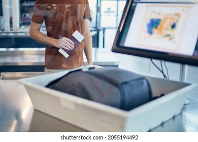 Airport security check. Young man waiting for x-ray control his bag. - Shutterstock ID 2055194492