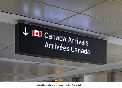 Airport sign indicating Canada Arrivals in English and French with an image of the Canadian Flag
