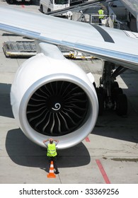 Airport technician looking into the engine