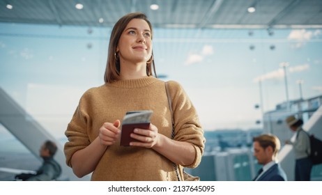 Airport Terminal: Happy Traveling Caucasian Woman Waiting at Flight Gates for Plane Boarding, Uses Mobile Smartphone, Checking Trip Destination on Internet. Smiling White Female on Vacation Trip - Powered by Shutterstock