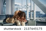 Airport Terminal: Woman Waits for Flight, Uses Smartphone, Receives Bad News, Starts Crying. Upset, Sad, and Dissappointed Person Misses Her Flight while Sitting in a Boarding Lounge of Airline Hub.