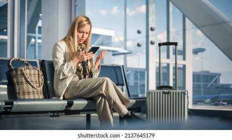 Airport Terminal: Woman Waits For Flight, Uses Smartphone, Receives Shockingly Bad News, Starts Crying. Upset, Sad, And Dissappointed Person Sitting In A Boarding Lounge Of Airline Hub.