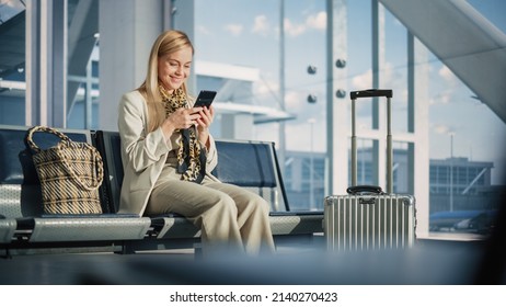 Airport Terminal: Woman Waits for Flight, Uses Smartphone, Browse Internet, Social Media, Online Shopping. Traveling Female Remote Work Online on Mobile Phone in a Boarding Lounge of Airline Hub - Shutterstock ID 2140270423
