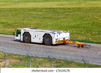 Airport Tug Tractor Moves At The Airport On The Field