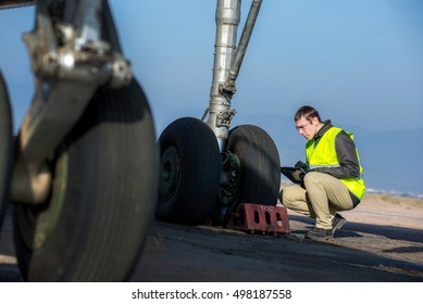 Airport Worker Checking Chassis