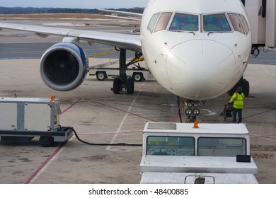 Airport Worker And Parked Airplane