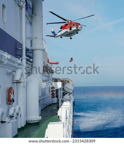 Air-sea rescue operations. Red rescue helicopter and Oil Tanker Ship . rescue team. The Coast security. The accident on the water. Ship have Emergency Accident. Training air sea recue operations. 