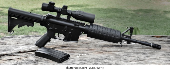 Airsoft gun or bb gun with white plastic bullets on wooden floor, soft and selective focus on airsoft gun.