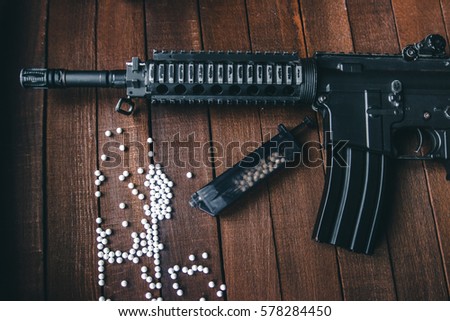 airsoft loader is on the table with a rifle and white balls