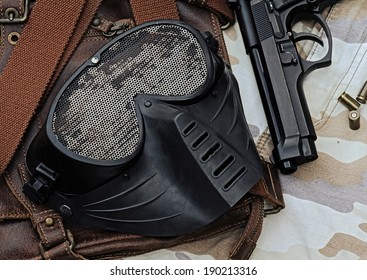Air-soft mask lying over a Leather handbag, Face protection from BB Gun Shooting game.