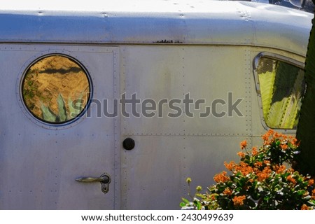 Airstream Van with circular windows and succulents, and cactus in nature. Van life.