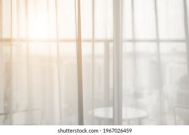 airy or thin and transparent white sheer curtain for see through and soft warm sun light on balcony close window in room for city home or hotel interior decor on morning feel and hot summer background - Shutterstock ID 1967026459