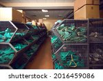 Aisle between rows of storage containers full of shoe form lasts and cardboard boxes with footwear standing in warehouse of shoe making factory. Manufacturing industry and footwear production concept