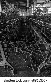 Aisle of machines at an abandoned silk mill.