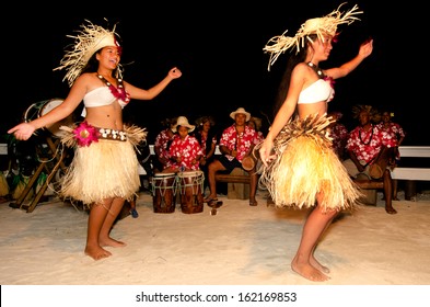 AITUTAKI - SEP 19 2013:Young adult Pacific Islanders women dancing Ura, a sacred ritual usually performed by a female who moves her body to tell a story, accompanied by intense drumming. 