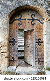 Ajar Old Wooden Door In Stone Arch