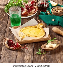 Ajaruli Khachapuri with Pomegranate, Walnuts, and Fresh Herbs on Rustic Table. - Powered by Shutterstock