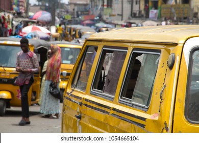 Ajegunle City, Lagos State/Nigeria- March 22, 2018: Yellow Bus Parked On Crowded Street