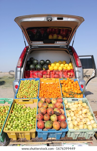 Ajman, United Arab Emirates - March\
18, 2020: A fruit seller operates from a parked car at the roadside\
in Ajman emirate, attracting customers as they drive by.\
