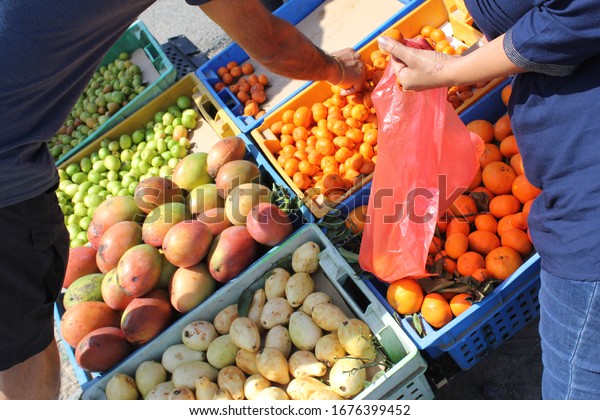 Ajman, United Arab Emirates - March\
18, 2020: A fruit seller operates from a parked car at the roadside\
in Ajman emirate, attracting customers as they drive by.\
