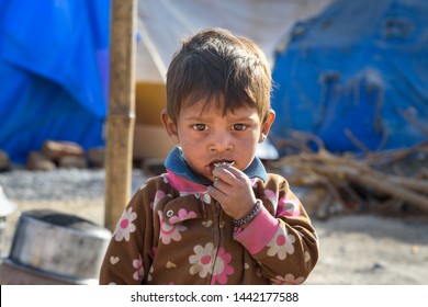Ajmer, India - February 07, 2019: Portrait of Indian boy on the street. Poor people come with family to the city from the village for work. And they living in the street in tent home. Rajasthan