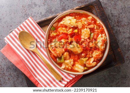 Ajoarriero is a traditional Spanish dish consists of shredded salt cod that's combined with tomatoes, garlic, onions, red and green peppers closeup on the bowl. Horizontal top view from above
