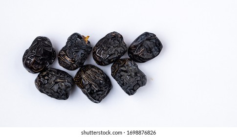 Ajwa Dates or "Kurma Ajwa" in a small plate isolated on white background. Prophet dates is one of the special fruit of Arabic .