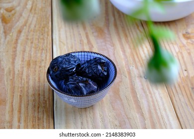 Ajwa Dates or "Kurma Ajwa" in a small plate isolated on wooden background. Prophet dates is one of the special fruit of Arabic .