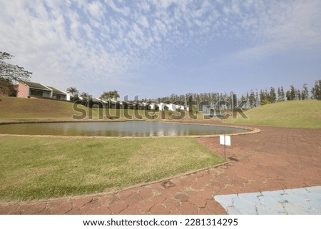 ake with boulder stones background in luxury resort for tourists. Apartments in the background. panoramic. wide angle.