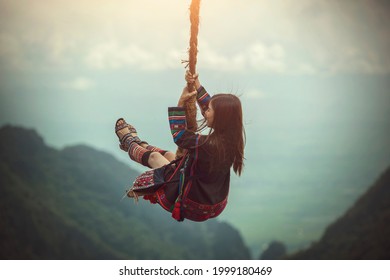 Akha girl , Hill tribe in the north of Thailand, Unidentified hill tribe was playing traditional wooden swing with traditional clothes and silver jewelry