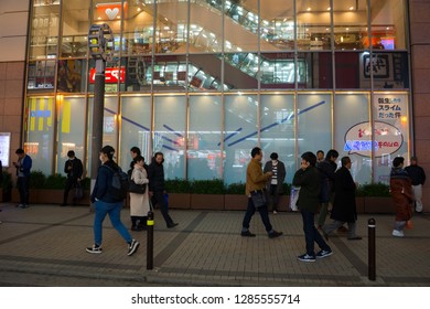 Akihabara, Japan- January 5, 2019: People walk past a poster in Akihabara.