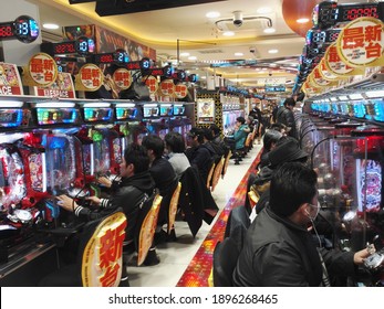 Akihabara Tokyo  Japan 18 January  2017;  Interior of  video game arcade  in Akihabara  district of  Tokyo  with players sitting  in front of gaming machines.