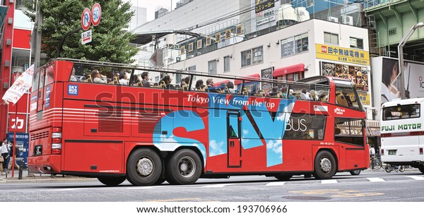 AKIHABARA, TOKYO - MAY 12: Sky Bus Tokyo running\
on the Chuo Dori Street, operated by Hinomaru Jidosha Kogyo, a\
tourist bus operator on May 12, 2014. The first open top tourist\
bus in Japan.