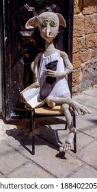 Akko Acre, Israel - July 29, 2020: Original Homemade Doll Sits On An Old Chair Outside Near The Door On A Sunny Day