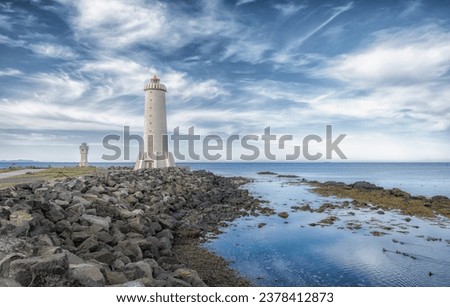Akranes lighthouses on the west coast of Iceland. Bigger lighthouse is operational and smaller is deactivated old one. White building by the sea