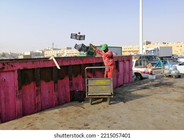 Al Ahsa Saudi Arabia Oct 2022, A Sanitation Worker In Al Ahsa Vegetables Traditional Market Throwing Trashes Into The Dump Bin, Under Morning Sun. 