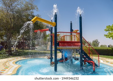 "Al Ain, Abu Dhabi, United Arab Emirates - March 29, 2021 - Empty Water park splash pad for children's summer fun in the sun. Fountains above and below." - Shutterstock ID 1949346232