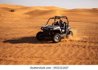 Al Aweer, Dubai, UAE - 12.13.2014: Man Ride And Drift Two Seats Quad Bike, Buggy Car At Desert Sandy Dunes, Fun Adventures At Wild Nature  