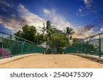 the Ala Wai Canal Path along the Ala Wai Canal with lush green palm trees, flowers, hotels and luxury condos, powerful clouds at sunset in Honolulu Hawaii USA