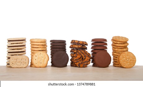 Alameda, CA - April 19, 2019: Stacks Of Popular Girl Scout Cookies, Available Annually During Girl Scout Cookie Sales, On A Wood Table With White Background. 