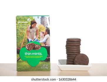 Alameda, CA - Jan 29, 2020: Box Of Girl Scout Brand Thin Mints Cookie. The Number One Cookie Sold By Girl Scouts Annually. On A Wood Table With Plate Of Cookies Stacked Next To Box.