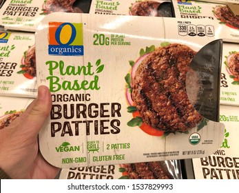 Alameda, CA - Oct 18, 2019: Grocery Store Refrigerator Section Hand Holding Organics Brand Plant Based Burger Patties. Plant Based Proteins Can Be As Healthy As Animal Based Proteins.