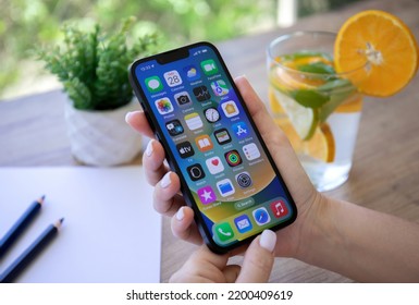 Alanya, Turkey - July 28, 2022: Woman Hand Holding IPhone 13 With Home Screen IOS 16 On The Screen.