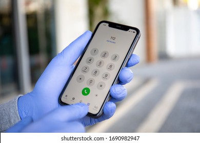 Alanya, Turkey - March 24, 2020: Man Hand In Disposable Protective Glove Holding IPhone 11 With Call Number Sos On The Screen.